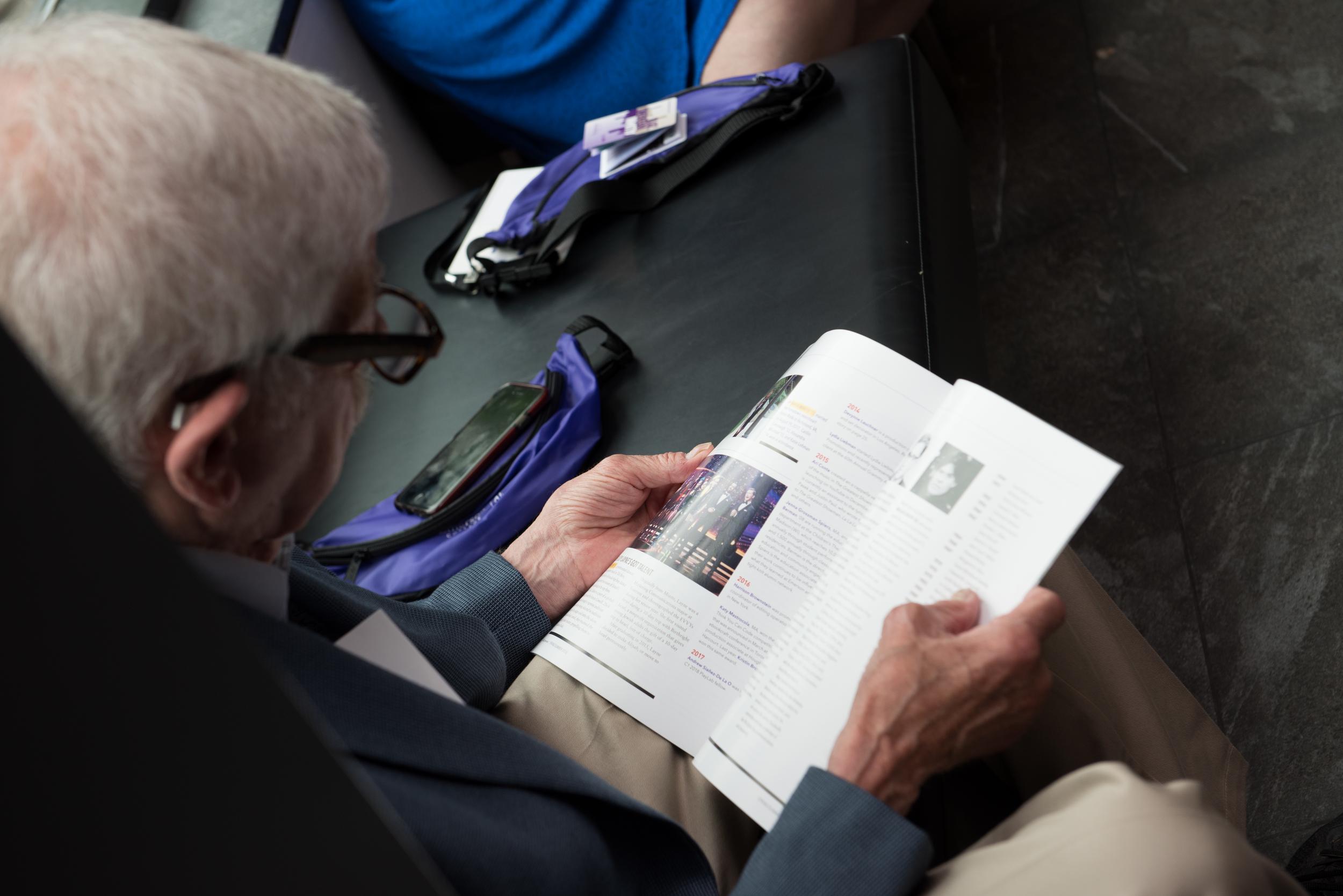Alumnus looking through a copy of Expression magazine
